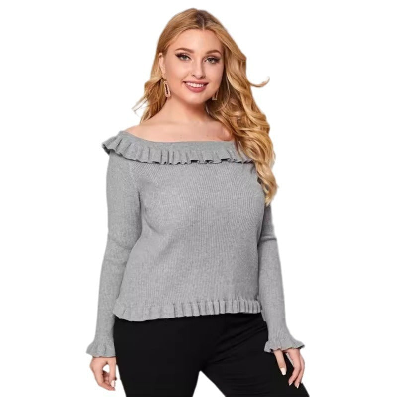 A woman wearing a gray off-shoulder sweater with ruffle detailing and long sleeves.