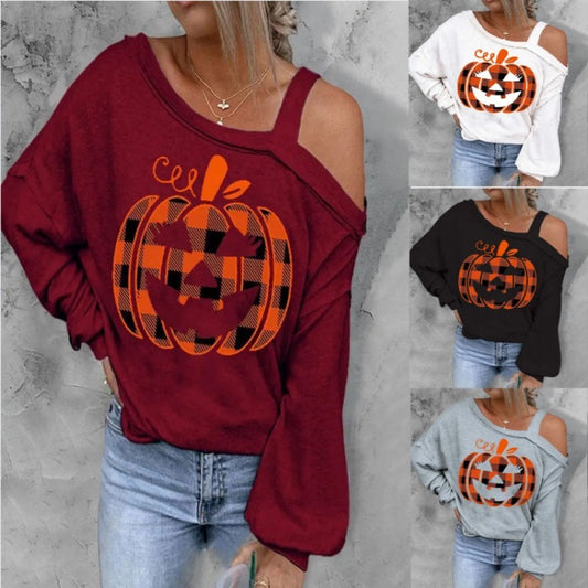 Red sweatshirt with pumpkin design worn by a person on a gray background
