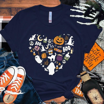 Navy blue t-shirt with Halloween-themed design on a wooden surface with shoes and decorations.