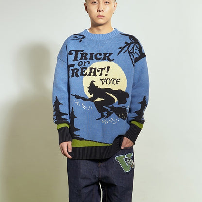 Person wearing a blue sweater with 'Trick or Treat! Vote' design on a plain background