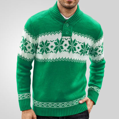 Green sweater with white snowflake pattern worn by a person on a gray background