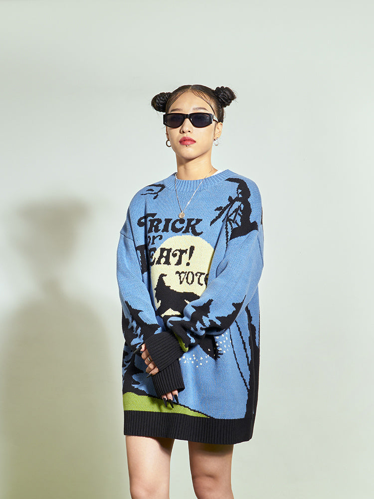 Person wearing a blue sweater with graphic design on a plain background