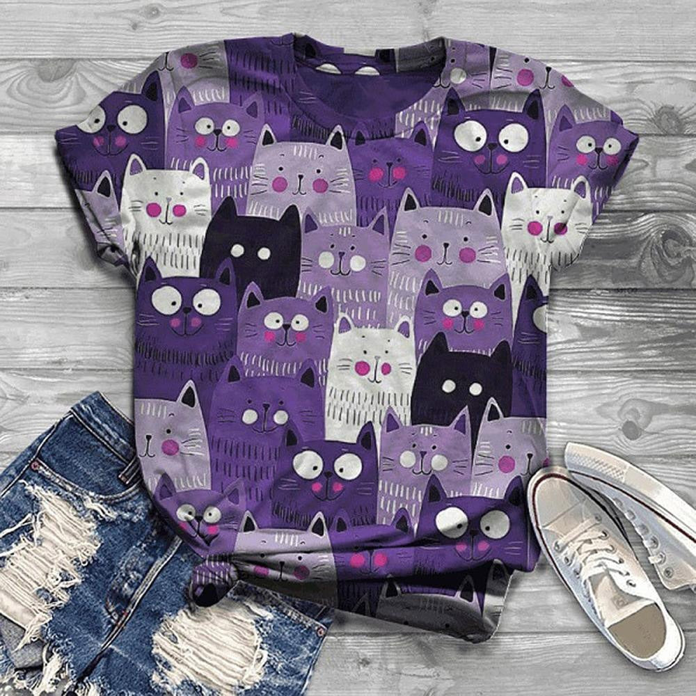 Purple t-shirt with cat pattern on a wooden surface with jeans and shoes.
