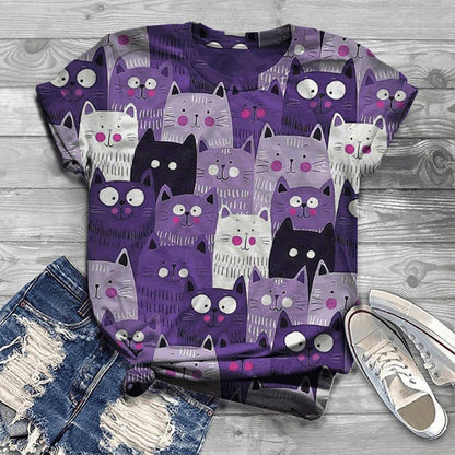Purple t-shirt with cat pattern on a wooden surface with jeans and shoes.