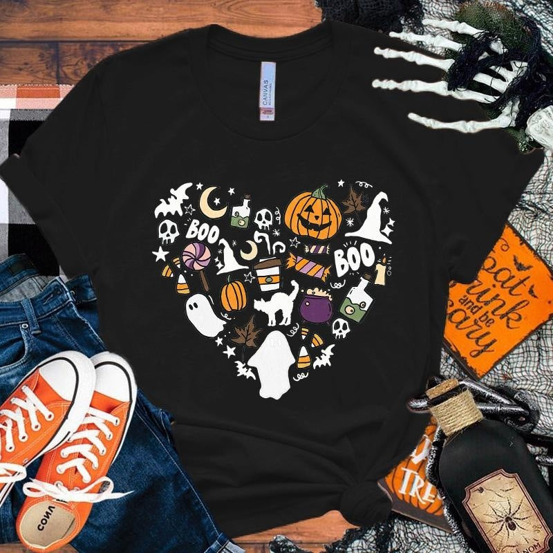 Black t-shirt with Halloween-themed design on a wooden surface with accessories.