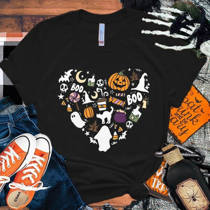 Black t-shirt with Halloween-themed design on a wooden surface with accessories.
