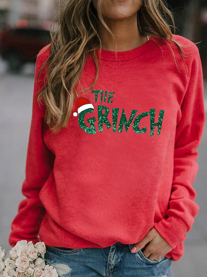 Red sweatshirt with 'The Grinch' text and Santa hat graphic worn by a person.