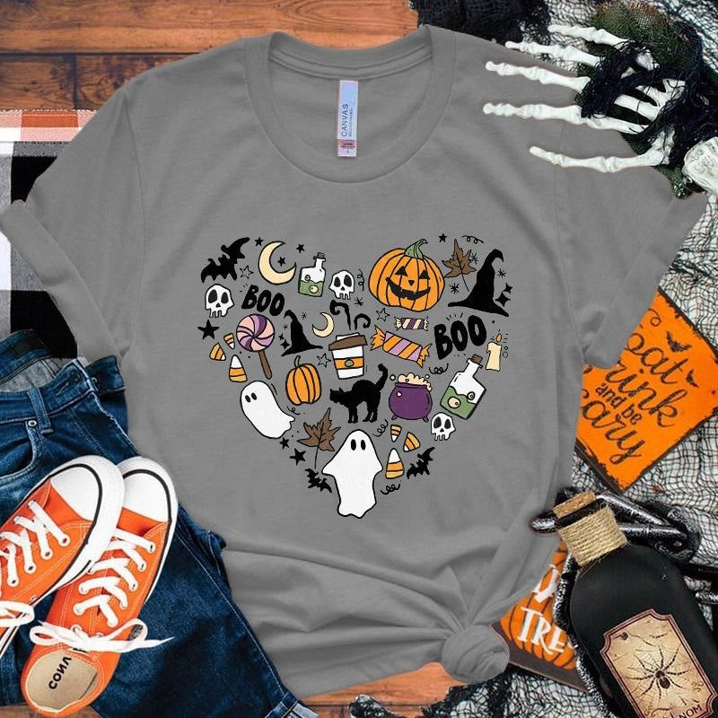 Gray t-shirt with Halloween-themed design on a wooden surface with accessories.