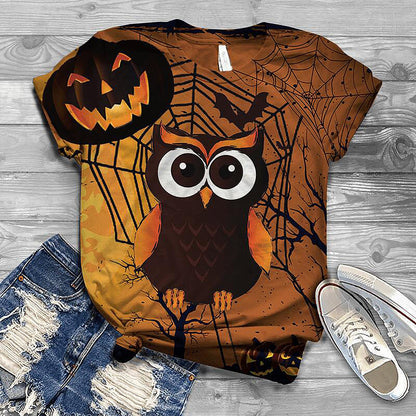 Halloween-themed t-shirt with owl and pumpkin design on a wooden surface.