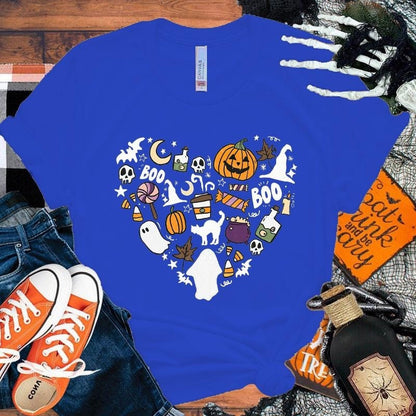 Blue t-shirt with Halloween-themed design on a wooden surface with accessories.