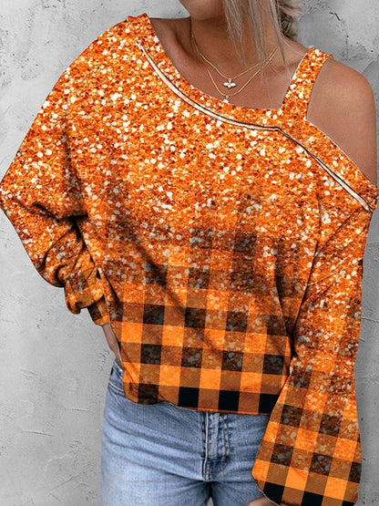 Person wearing an orange and black checkered top with a plain background