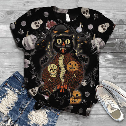 Halloween-themed t-shirt with black cat and pumpkins design on a wooden surface with jeans and sneakers.