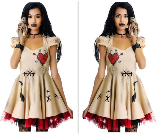 Woman wearing a beige dress with red and black designs, holding small animals.
