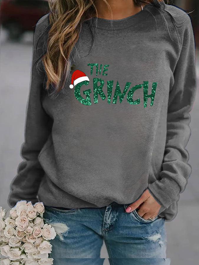 Gray sweatshirt with 'The Grinch' text and Santa hat graphic, worn by a person.