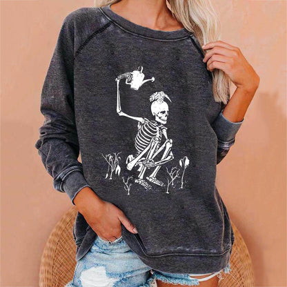 Person wearing a dark gray sweatshirt with a skeleton design on a beige background