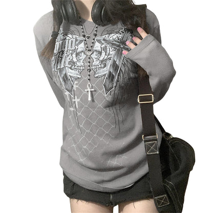 Person wearing a gray hoodie with a skull design, holding headphones, and carrying a black bag.